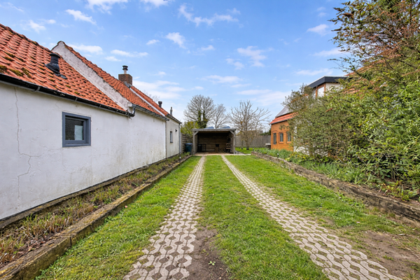 Rustieke oprit tussen oude huizen.png